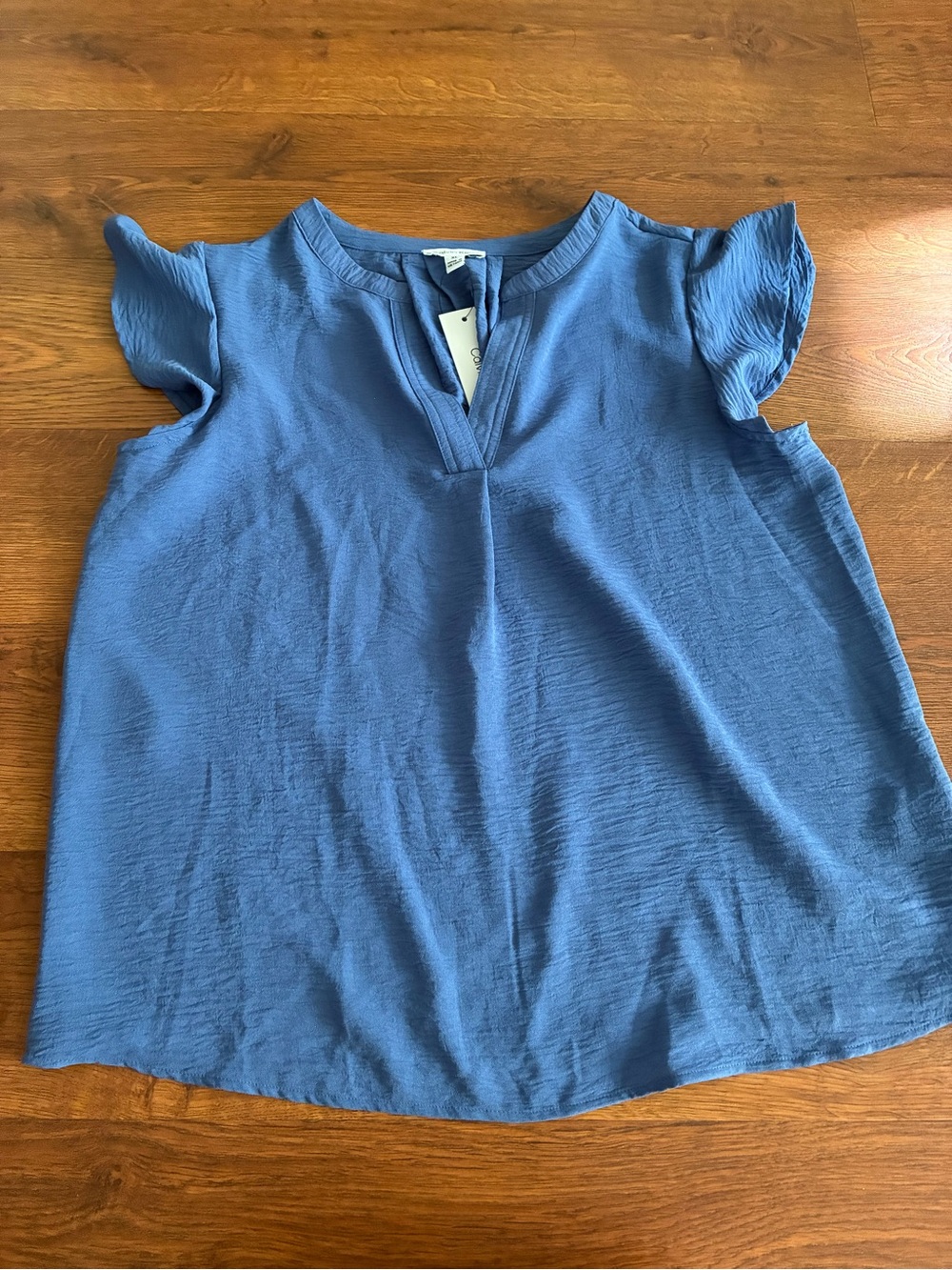 New Calvin Klein blouse features a split V-neckline and feminine flutter/ruffle